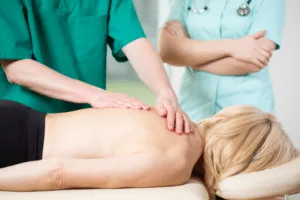 A woman getting a back massage from a doctor.