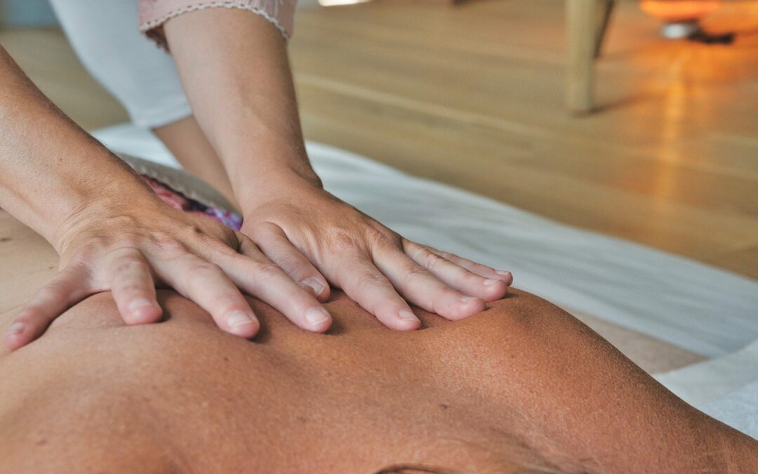 A woman receiving a holistic back massage therapy for chronic pain relief at a spa.